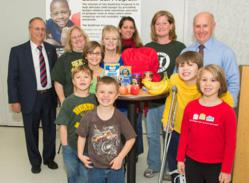 Dr. John Bennett, president & CEO of CDPHP, left, and Mark Quandt, executive director of the Regional Food Bank of Northeastern New York, right, kicked off the 12th annual CDPHP Holiday Appeal to benefit the Food Bank’s BackPack Program. They were joined by BackPack Program participants Lauren Charlebois, center (in blue), and her five grandchildren along with representatives from Heatly School in Green Island, from left, Karin Thuber, Lynn Fraim and Kendell Hardy.